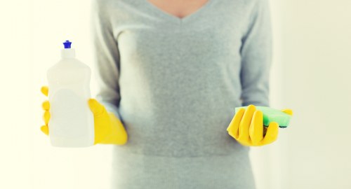 Cleaner wearing PPE while operating carpet cleaning equipment